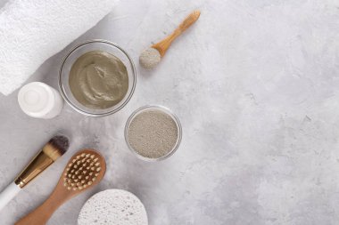 Cilt ve saç için kozmetik kil tozu, kaplıca ve sağlık, doğal kozmetik ürünleri ve açık gri arka planda fotokopi alanı olan fırçalar.