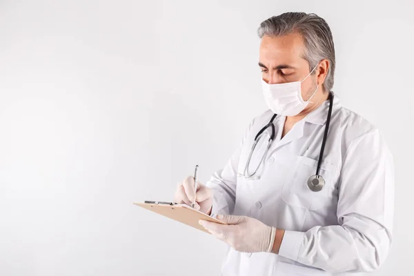 Close Médico Masculino Usando Máscara Luvas Segurando Prancheta Preenchendo Formulário — Fotografia de Stock