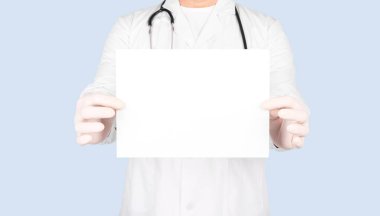 Doktor boş kağıt ve metin için kopyalama alanı gösteriyor. Mavi arkaplan üzerinde izole edilmiş.