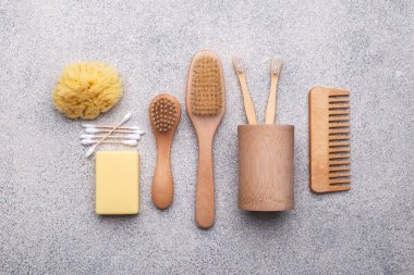 Sıfır atık yeniden kullanılabilir banyo öğeleri doğal taş arka plan, ahşap tarak, diş fırçası, deniz süngeri, kulak çubuğu, katı sabun, düz yatak