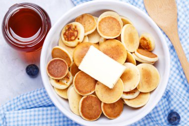 Gri taşlı arka planda bal ve yaban mersinli ev yapımı mini gözlemeler, yakın plan, yatay