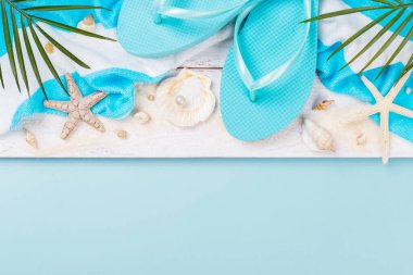 Mavi arka planda plaj aksesuarları, güneş gözlüğü, güneş kremi, parmak arası terlik, havlu ve şapka, yaz tatili konsepti, fotokopi alanı