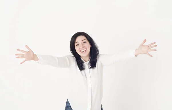 Mujer joven en una blusa blanca se prepara para abrazar a alguien, extendiendo sus manos y saludando sonriendo . — Foto de Stock