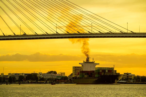Container lading Oceaan schip drijven op de rivier en passeren onder brug — Stockfoto