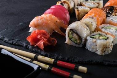 Siyah taşla servis edilen çeşitli suşiler.
