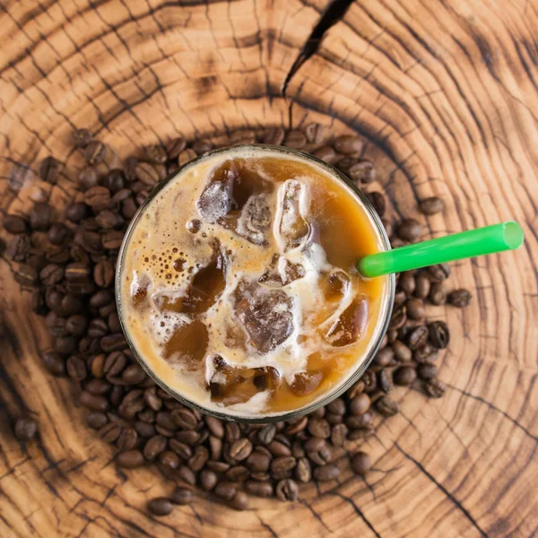 、木製の背景にコーヒー豆のテイクアウト カップでアイス コーヒー ロイヤリティフリーのストック画像