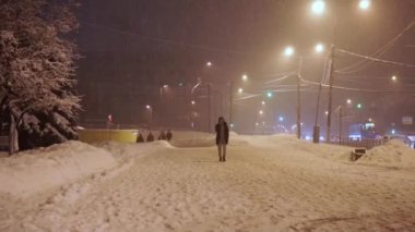 Akşamları kaldırım anormal kar yağışı altında yayalar acele
