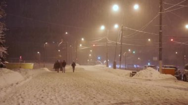 Akşamları kaldırım anormal kar yağışı altında yayalar acele