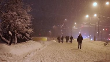 Akşamları kaldırım anormal kar yağışı altında yayalar acele