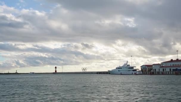 Vista panorámica del puerto de Sochi, anillos olímpicos en la luz del atardecer, mar tranquilo — Vídeos de Stock