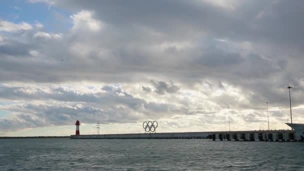 Vista panorâmica do porto marítimo de Sóchi, anéis olímpicos à luz do pôr do sol, mar calmo — Vídeo de Stock