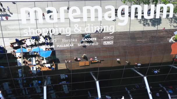 Voetgangers in de buurt van spiegel uithangbord van winkelen amusementscentrum Maremagnum — Stockvideo