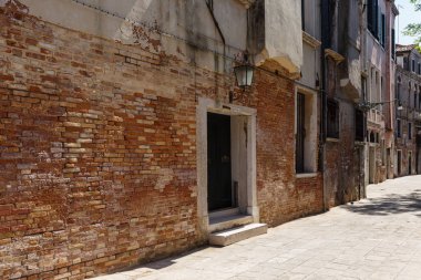 Yaz güneşli gün dar bir Venedik sokakta tipik görünümü. Kırmızı tuğla bina