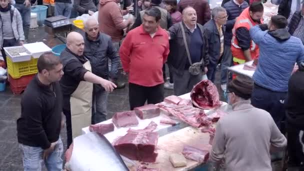 Tourist make photo of fish seller cut tuna with knife cleaver. Market in Catania — ストック動画