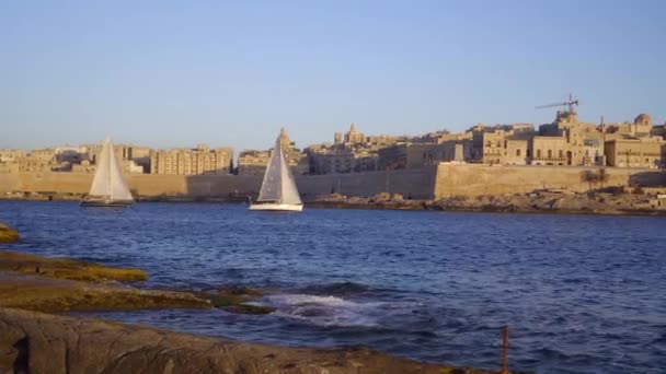 Sportovní jachty vstupují do přístavu, Bazilika Panna Maria Mount Carmel ve Vallettě, Malta — Stock video