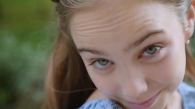 Mavi gözlü, uzun saçlı sarışın kız kameraya asık suratla bakar ve dans etmeye başlar.