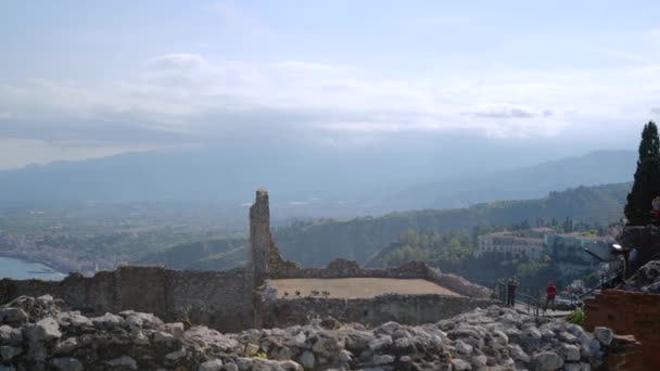 Los turistas caminan a través de las ruinas del anfiteatro griego antiguo en la puesta del sol — Vídeos de Stock