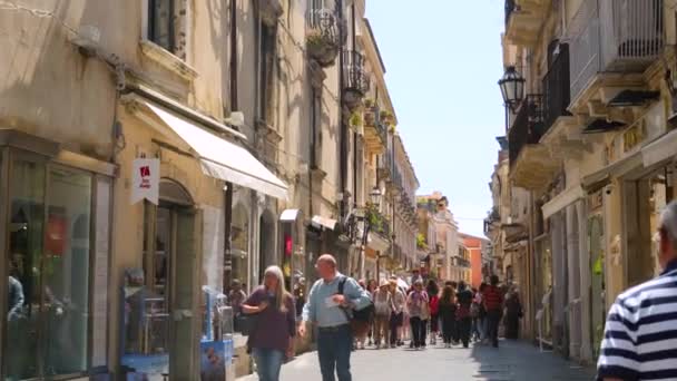 Pessoas na rua ensolarada lotada da cidade pequena acolhedora popular Taormina na Sicília — Vídeo de Stock