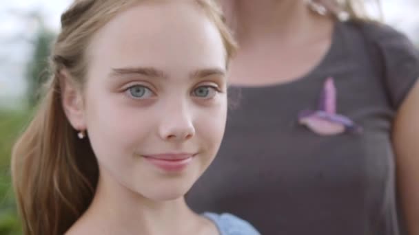 Anya támaszkodik a fiatalabb lánya, 10 éves lány mosolyog, közelről — Stock videók