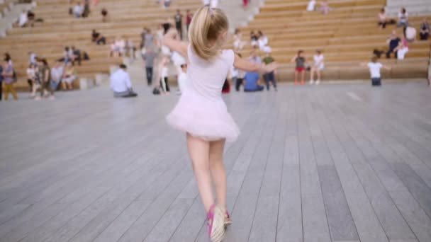 Dos adorables hermanas de pelo largo en vestidos azules y rosas bailando en escena al aire libre — Vídeos de Stock