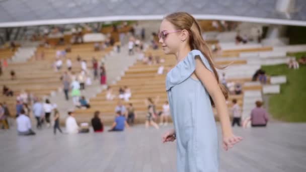 Two adorable long-hair sisters in blue and rose dresses dancing on openair scene — Stock Video