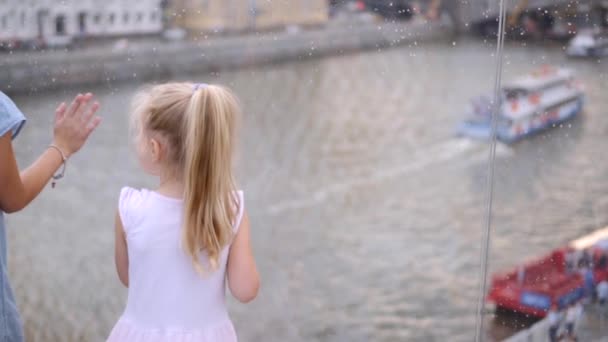 5 ve 9 yaşındaki iki kız kardeş, köprünün camından nehre bakıyor. Yavaş çekim — Stok video