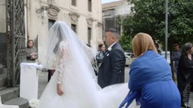 Aileleri olan gelin kiliseye gelmeye hazırlanıyor. Heyecanlı anne elbisesini yayar