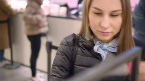 Mooie jonge mooie vrouw proberen smaken in de parfum afdeling van de winkel — Stockvideo