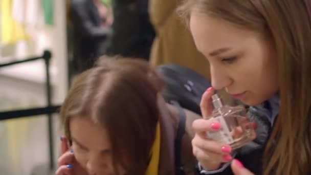 Mooie vrouw probeer smaken, geef het aan haar vriend, parfum afdeling van een winkel — Stockvideo