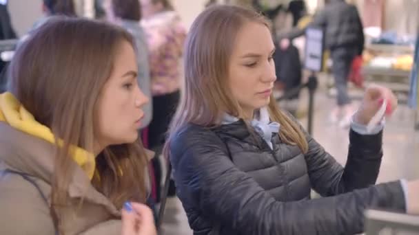 Mooie vrouw probeer smaken, geef het aan haar vriend, parfum afdeling van een winkel — Stockvideo