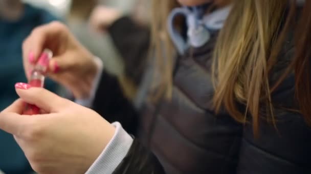 Mooie jonge vrouwen proberen vloeibare lippenstift kleur op haar hand, toon het aan haar vriend — Stockvideo