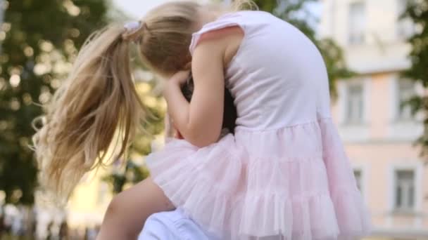 Adorable de pelo largo de 5 años de edad, niña en vestido de rosa está sentado en el hombro de los padres — Vídeos de Stock