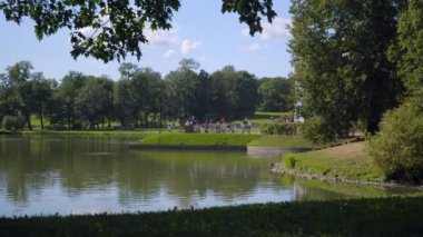 Turistler Alexandrovsky Park 'taki Büyük Göl kıyısında yürürler, ördekleri beslerler.