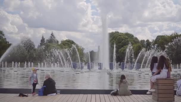 人々はモスクワのゴーキー公園の端にある図噴水の近くを歩く — ストック動画