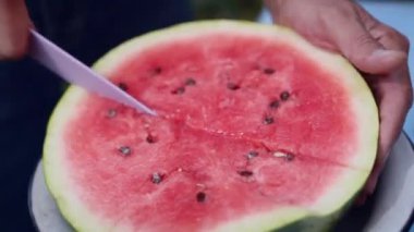 Adam olgun, sulu, lezzetli karpuz dilimler, açık havada