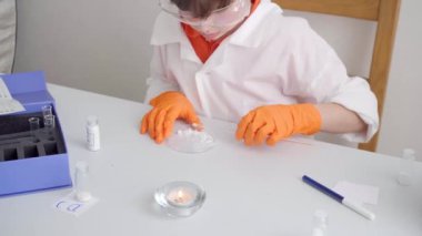 Çocuk deneysel olarak tuzu alevin rengine göre yanma reaksiyonuyla belirliyor.