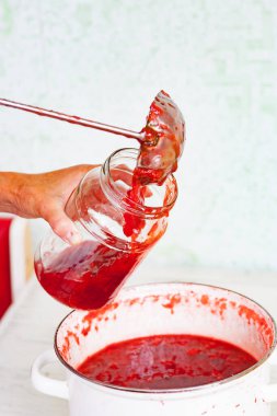 Çelik kepçeyle kavanoza reçel dök