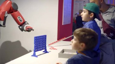 Çocuklar Eğitim Köşkünde Robostation sergisinde bir robotla oyun oynuyor