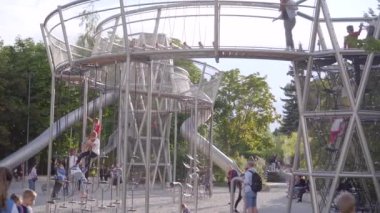 Köprüleri ve ağları olan karmaşık kulelere tırmanan pek çok mutlu çocuk. Gorky Parkı.