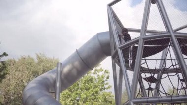 Köprüleri ve ağları olan karmaşık kulelere tırmanan pek çok mutlu çocuk. Gorky Parkı.
