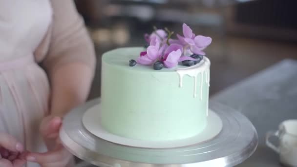 Confeiteiro decora ordenadamente bolo de biscoito de casamento turquesa com mirtilos — Vídeo de Stock