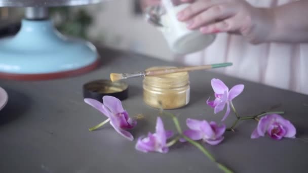 Konditor bereiten weiße Glasur, um den Kuchen zu dekorieren. Gold, Beeren, Blumen — Stockvideo