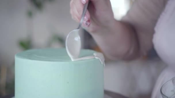 Confiseur fait exquis gouttes de glaçure blanche sur la surface turquoise de gâteau — Video