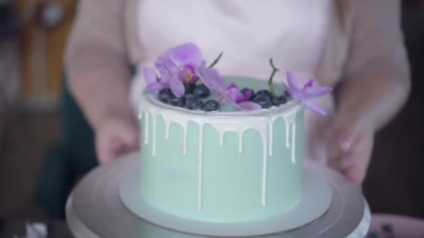 Confeiteiro decora ordenadamente bolo de biscoito de casamento turquesa com mirtilos — Vídeo de Stock