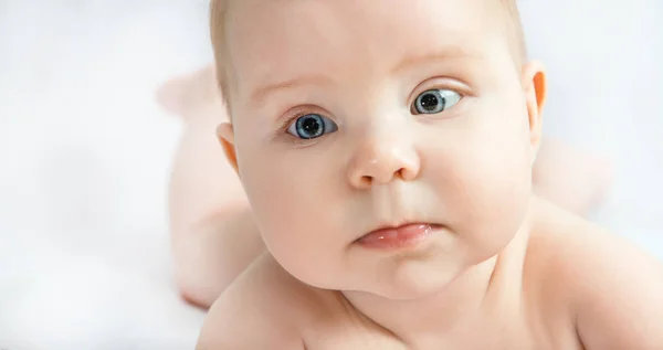 yatakta yatarken ve beyaz arka plan yakın çekim kameraya bakarak bebek