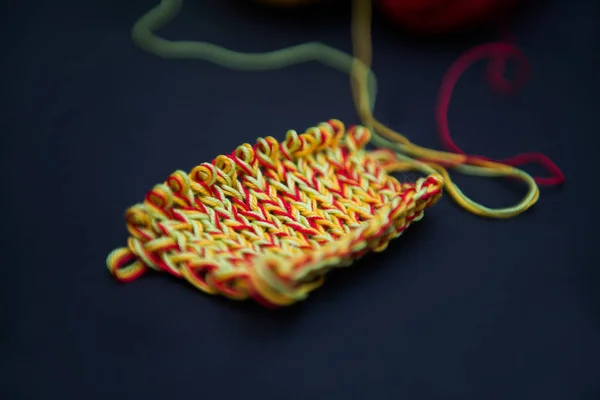 bir parça örgü üzerinde bir siyah arka plan, kırmızı, sarı, yeşil
