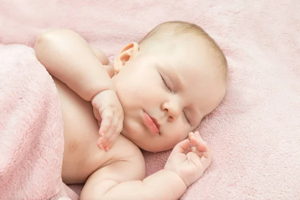 Malé dítě spí v posteli pod dekou růžové Stock Fotografie