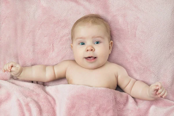 Niño sonriente acostado en la cama — Foto de Stock