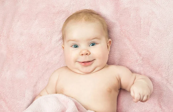 Niño sonriente acostado en la cama — Foto de Stock