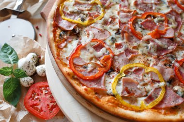 Etrafında pizza ve malzeme var.